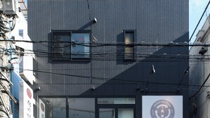 A building with a storefront featuring signage in a foreign language, a visible entrance, and a metal awning. - TD STAY TOKYO (Tokyo)