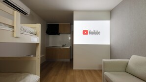 A room with a bunk bed, a sofa, a kitchen area, and a YouTube logo on the wall. - TD STAY TOKYO (Tokyo)