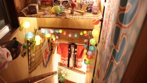 Una habitación con una cama, un ventanal y una pared decorada con diversos objetos.