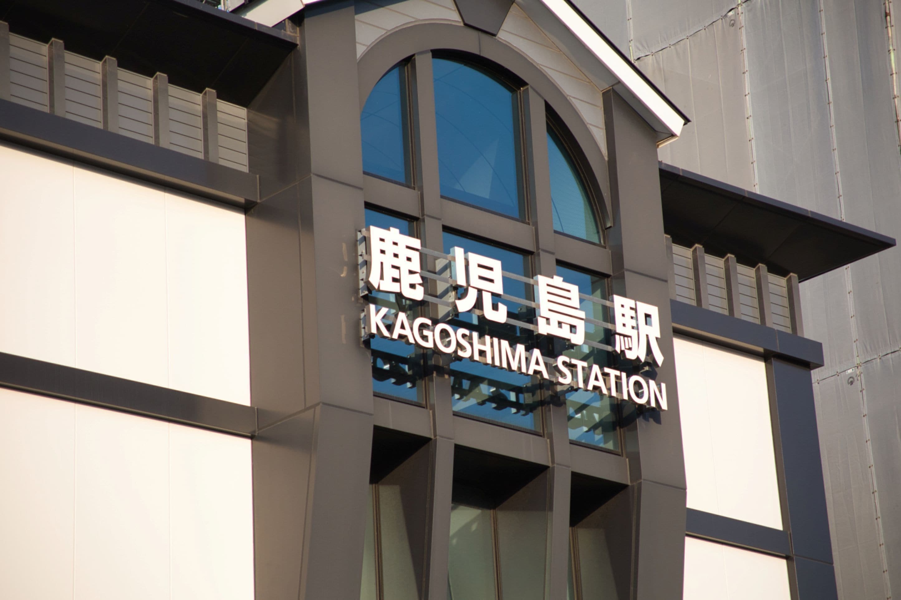 A building with a sign that reads 'KAGOSHIMA STATION' in English and another language.