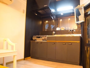 A kitchen with a built-in stove, cabinets, and a mirror above the sink.