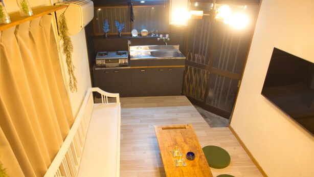 Una cocina compacta con un lavamanos, armarios y una mesa de madera con un objeto decorativo.