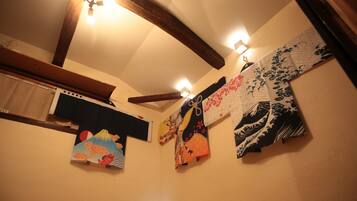 A room with wooden beams, a ceiling fan, and wall-mounted lights.
