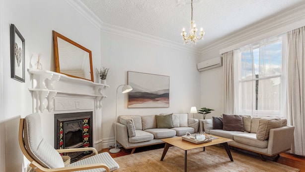 Ein Wohnzimmer mit Kamin, Sofa, Sessel und einer Chandelier.