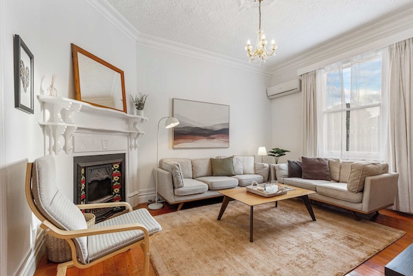 Ein Wohnzimmer mit Kamin, Sofa, Sessel und einer Chandelier.