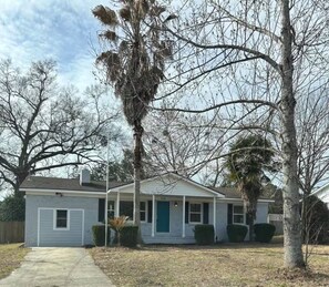 A single-story house with a front porch, a garage, and a small front yard.