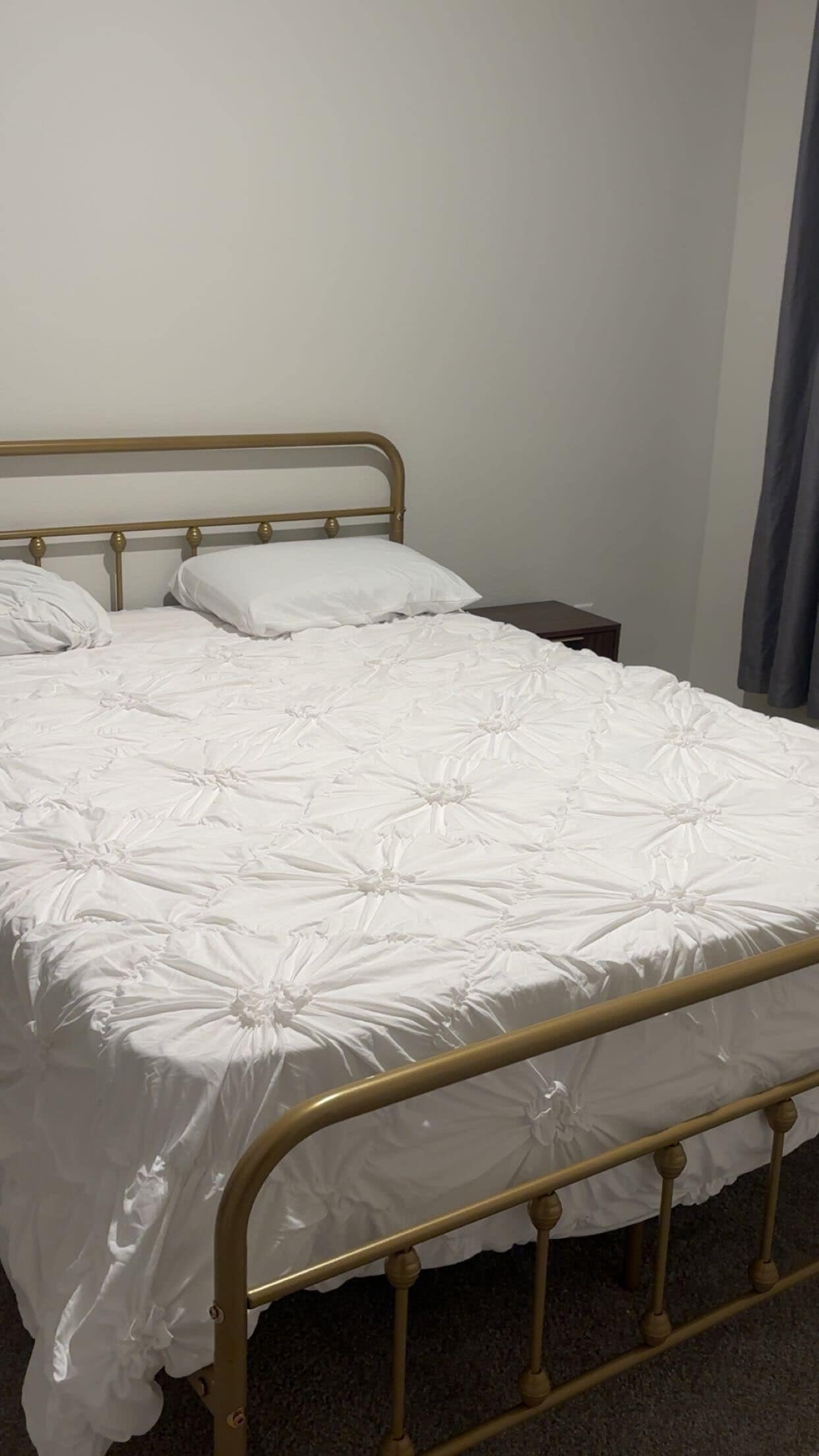 A single bed with a metal frame and white bedding.