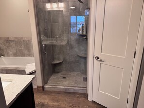 A modern bathroom with a glass-enclosed shower, a bathtub, and a toilet. - Spacious 4-bedroom house in charming Page with Indoor boat parking! (Page)