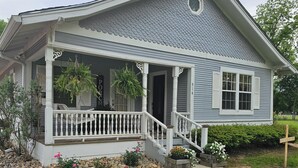 A house with a porch, a staircase, and a well-maintained garden.