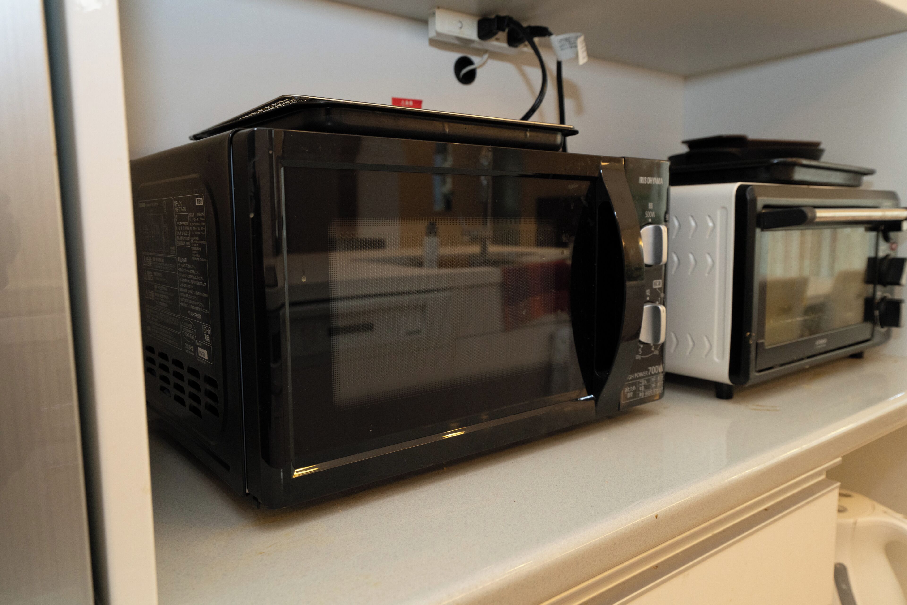 Una cocina con microondas y tostadora sobre la encimera.