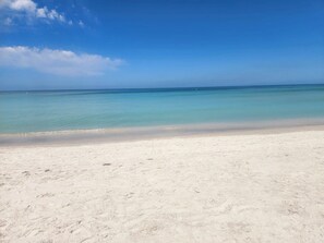 A beach with clear turquoise water and a sandy shore. - Luxe Coastal Retreat • 12 Min to Beach • Private Yard w/Games (Clearwater)