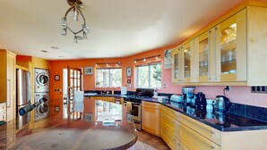 A kitchen with a central island, stainless steel appliances, and wooden cabinets. - Panoramic ocean view 4-bedroom house in charming Gualala perfect for relaxing . (Gualala)
