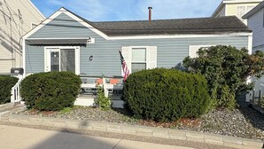 A residential house with a front porch, a mailbox, and a flag.