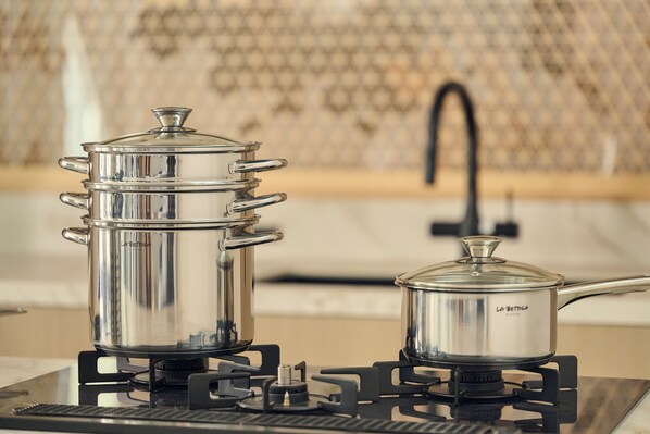 Two stainless steel pots on a portable gas stove.