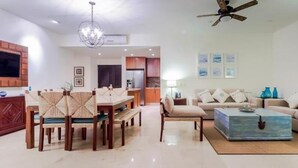 Una sala de estar moderna con comedor, un sofá, una mesa de centro y un televisor.