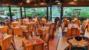 Un restaurante con varias mesas y sillas, algunas con manteles rojos.