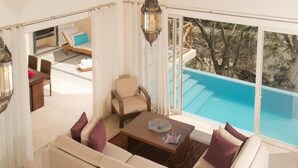 Amplia sala de estar con un sofá, una mesita de centro y vista a una piscina.