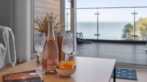 A table with a bottle of rosé wine, two glasses, a bowl of snacks, and a book titled "English Riviera". - Avocet 2 is a stylish coastal apartment offering uninterrupted sea views (Brixham)