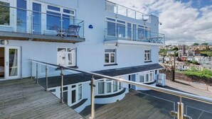 Ein zweistöckiges Gebäude mit Balkon, großen Fenstern und Blick auf die Stadt.