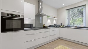 Una cucina moderna con forno integrato, microonde e cappa aspirante in acciaio inossidabile.