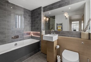 Ein modernes Badezimmer mit einer Badewanne, einem Waschbecken und einer Toilette.