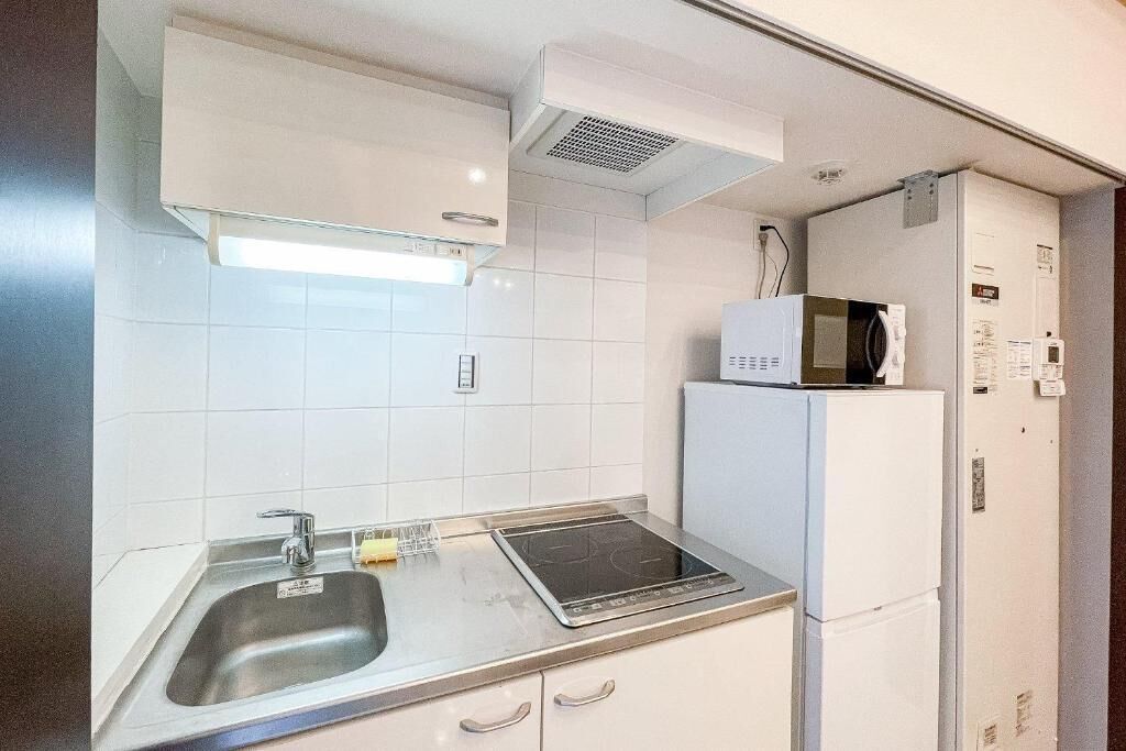 A compact kitchen with a sink, a microwave, and a built-in oven.