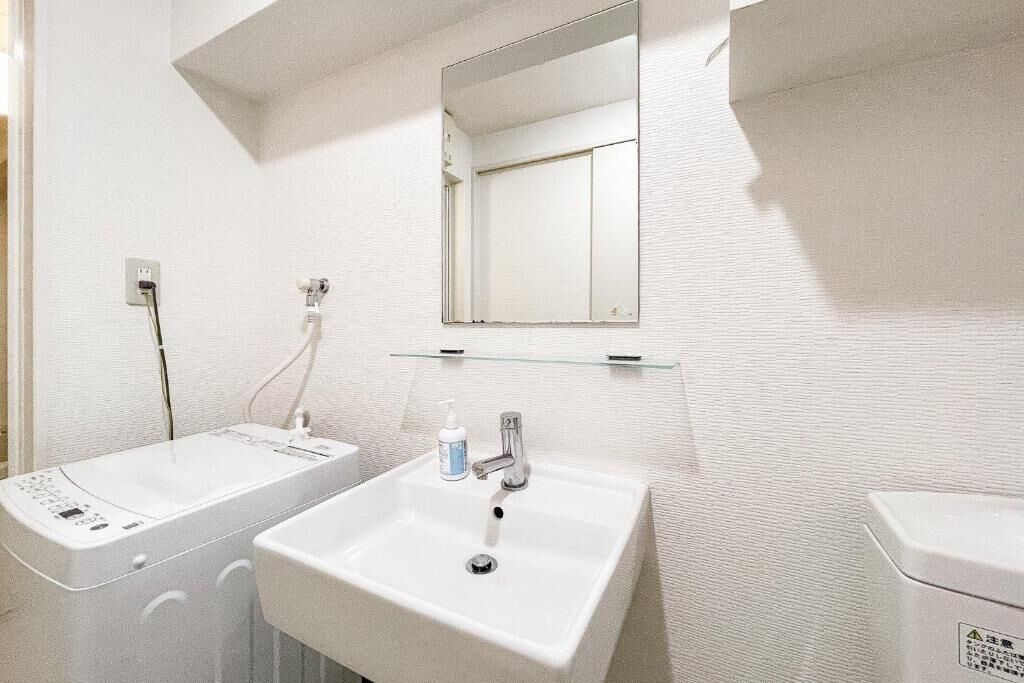 A bathroom with two sinks, a mirror, and a toilet.