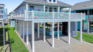 A waterfront house with a balcony, a covered patio, and a pool area. - Pearly Pelican 3 Bedroom Home (Port Bolivar)