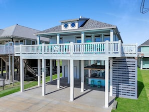 Ein zweistöckiges Haus mit Balkon, überdachter Terrasse und Poolbereich.