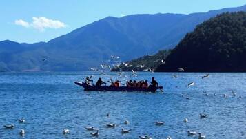A boat on a lake with mountains in the background.