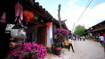 A traditional street with shops, a signboard, and a person walking.