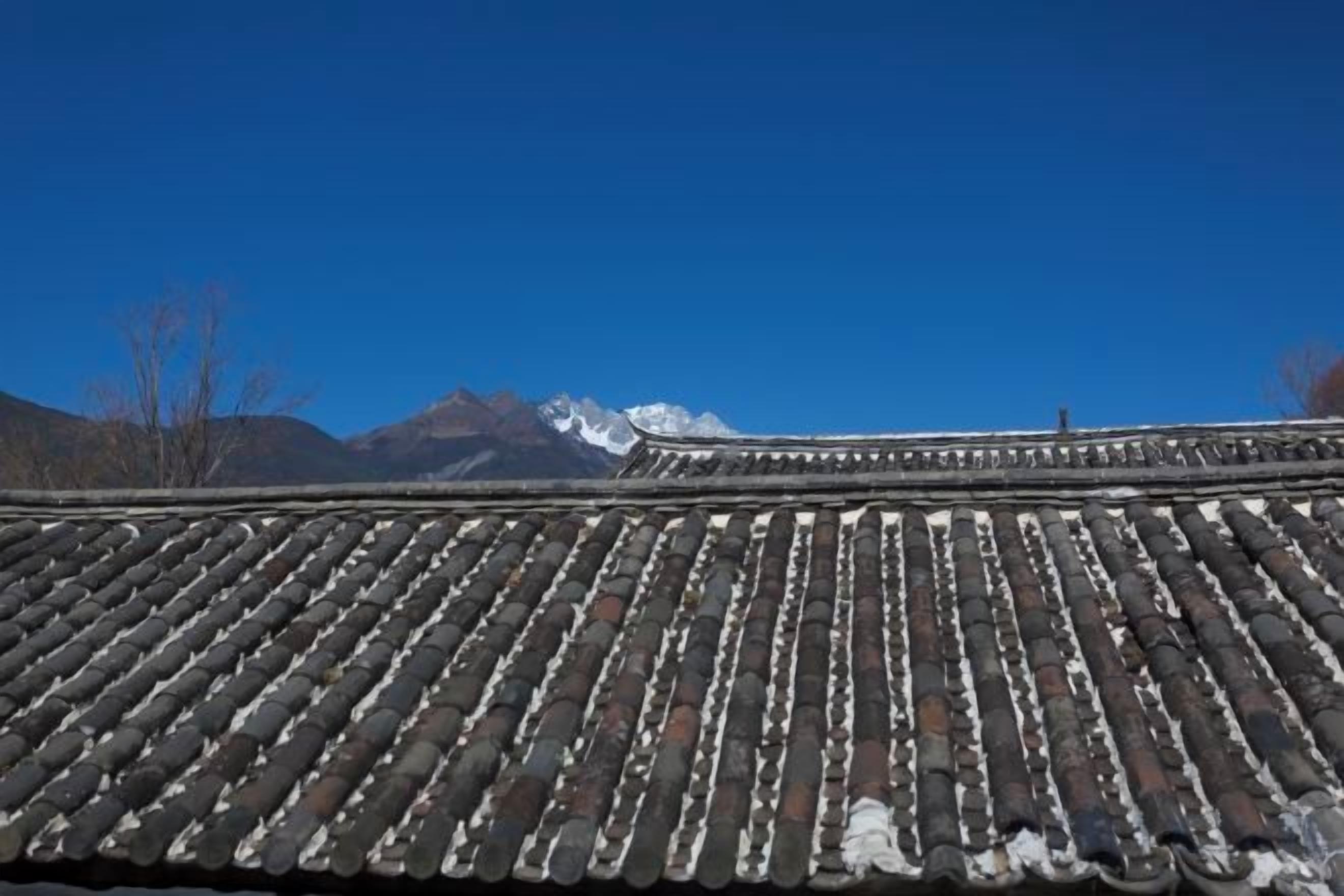 A traditional tiled roof with a mountainous backdrop.