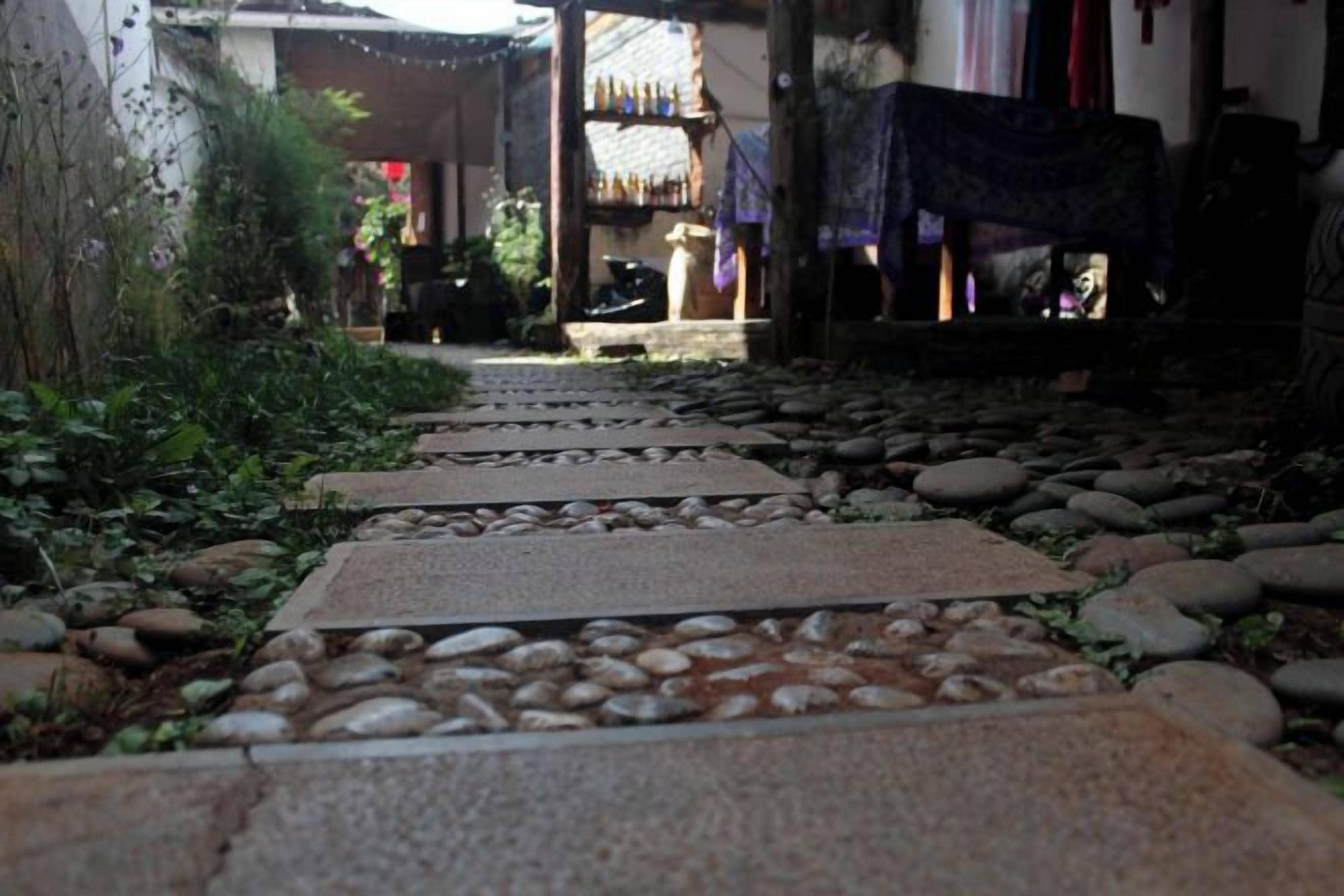 Un sendero de piedra que conduce a un edificio con porche cubierto.