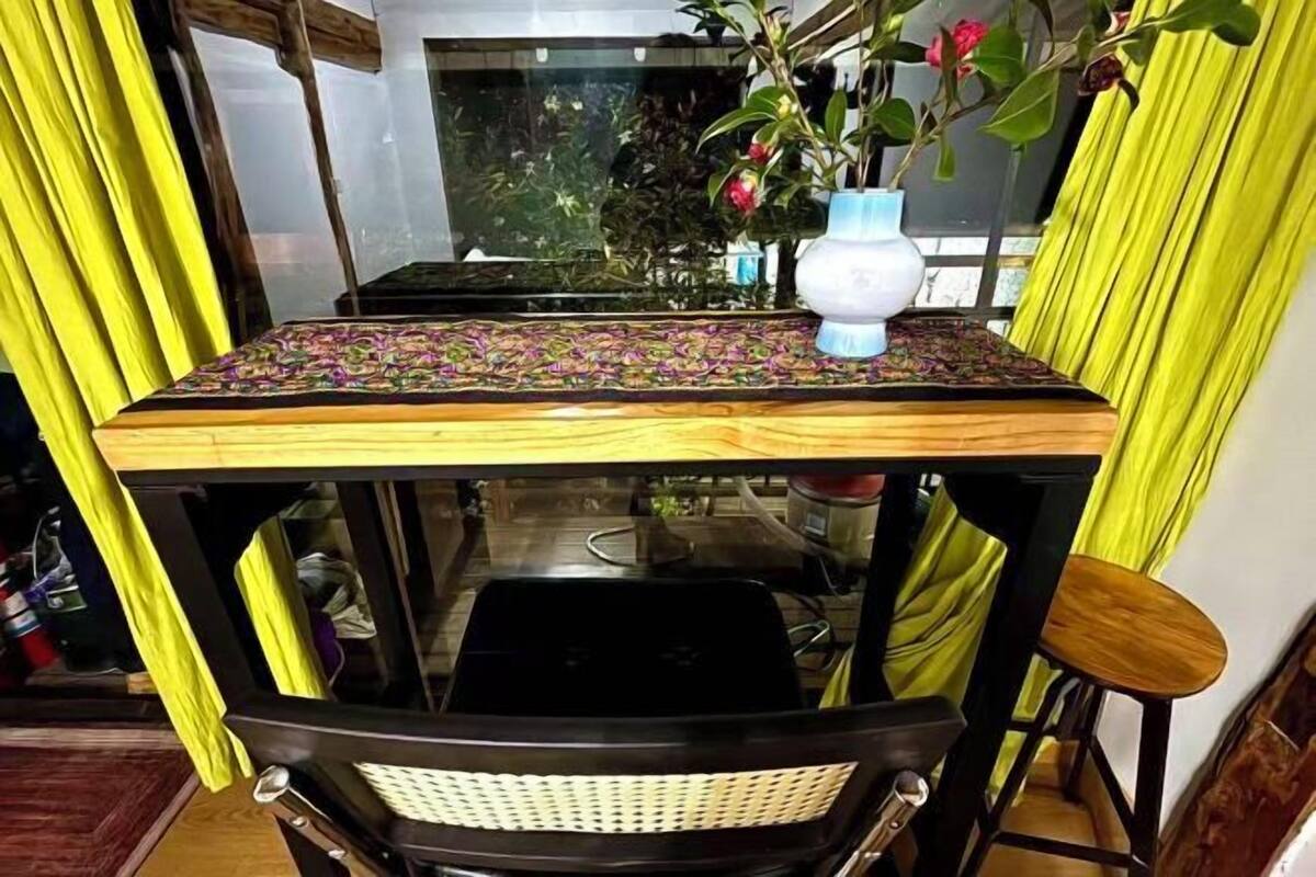 Una mesa de comedor con mantel estampado, un florero con flores y una silla.