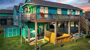 A two-story house with a balcony, a deck, and a small shed. - It's A Shellabration 3 Bedroom Home (Port Bolivar)