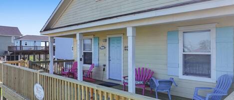 A two-story house with a porch, a covered deck, and a fenced yard.