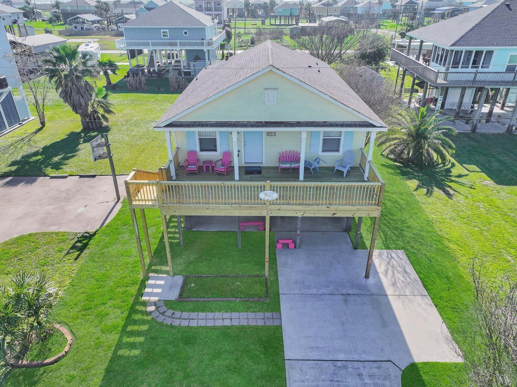 A two-story house with a covered porch, a small front yard, and a driveway.