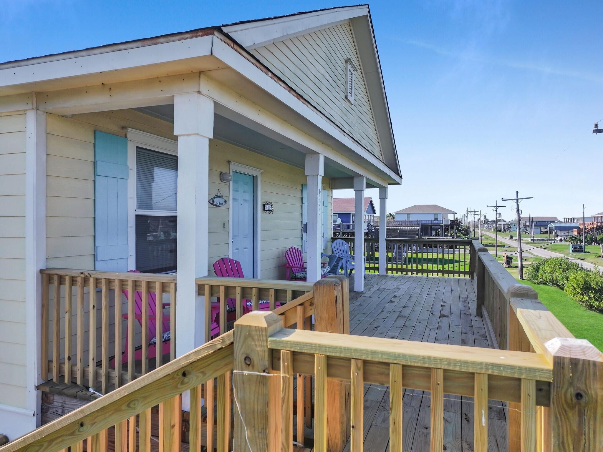 A wooden deck with a porch, a door, and a small sign.
