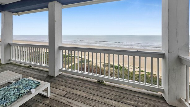 A covered outdoor area with a view of the beach, wooden flooring, and a white railing. - Crystal By The Ocean 4 Bedroom Home (Port Bolivar)
