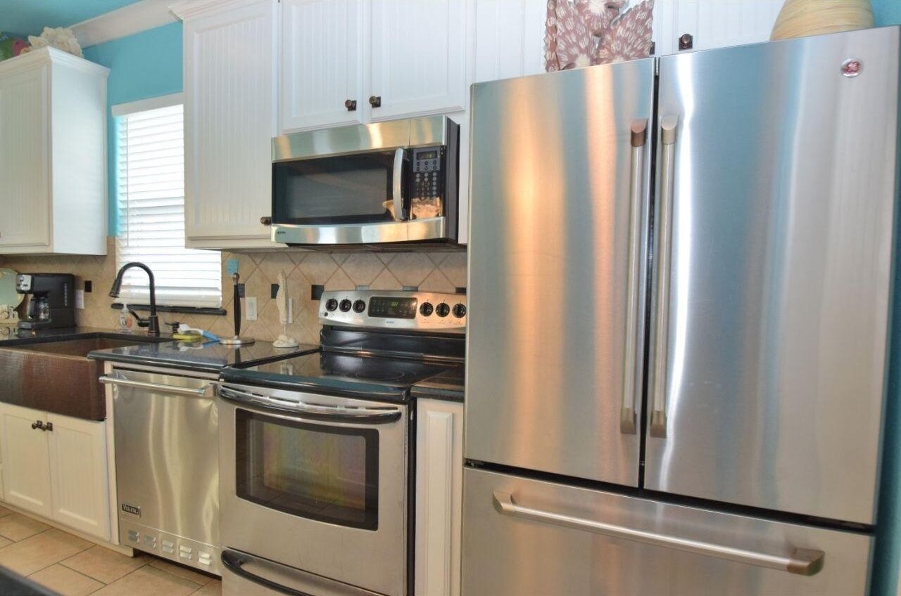 A kitchen with stainless steel appliances, including a microwave, oven, and refrigerator.