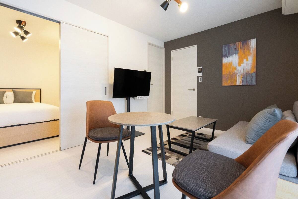 Une chambre d’hôtel moderne équipée d’un lit, d’une télévision, d’un canapé et d’une petite table.