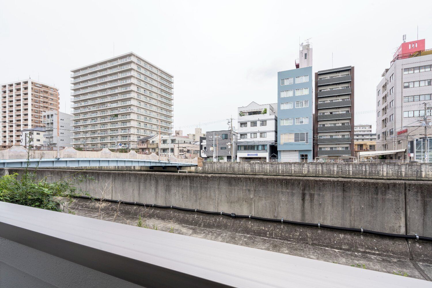 Une vue urbaine avec des bâtiments modernes, une voie ferrée et un pont.