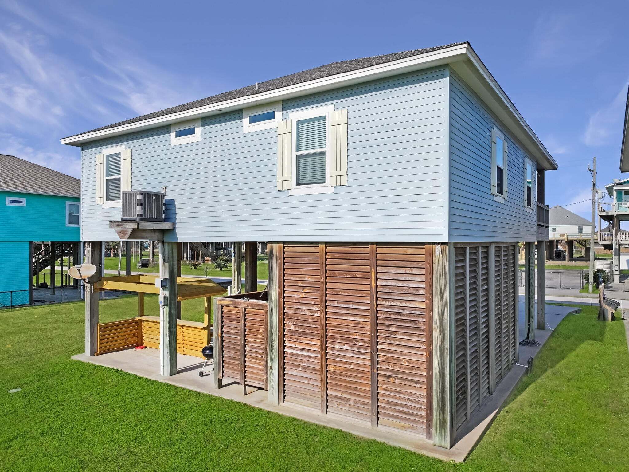 A two-story house with a covered patio area and a satellite dish.