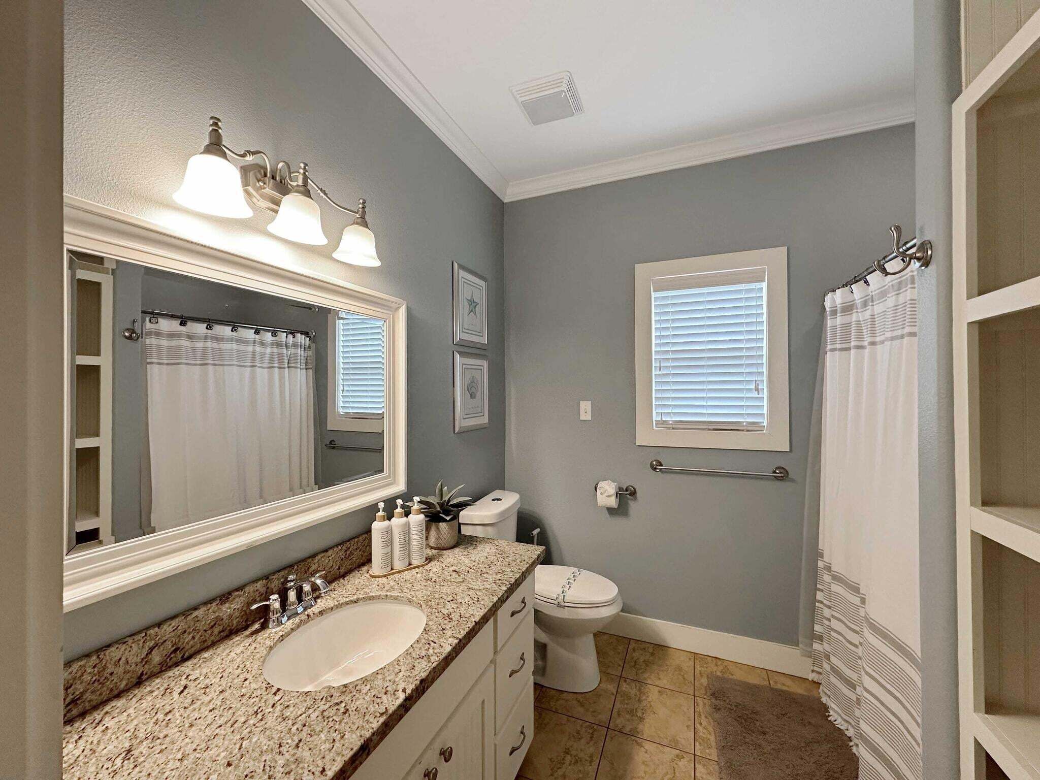 A bathroom with a sink, toilet, and shower area.