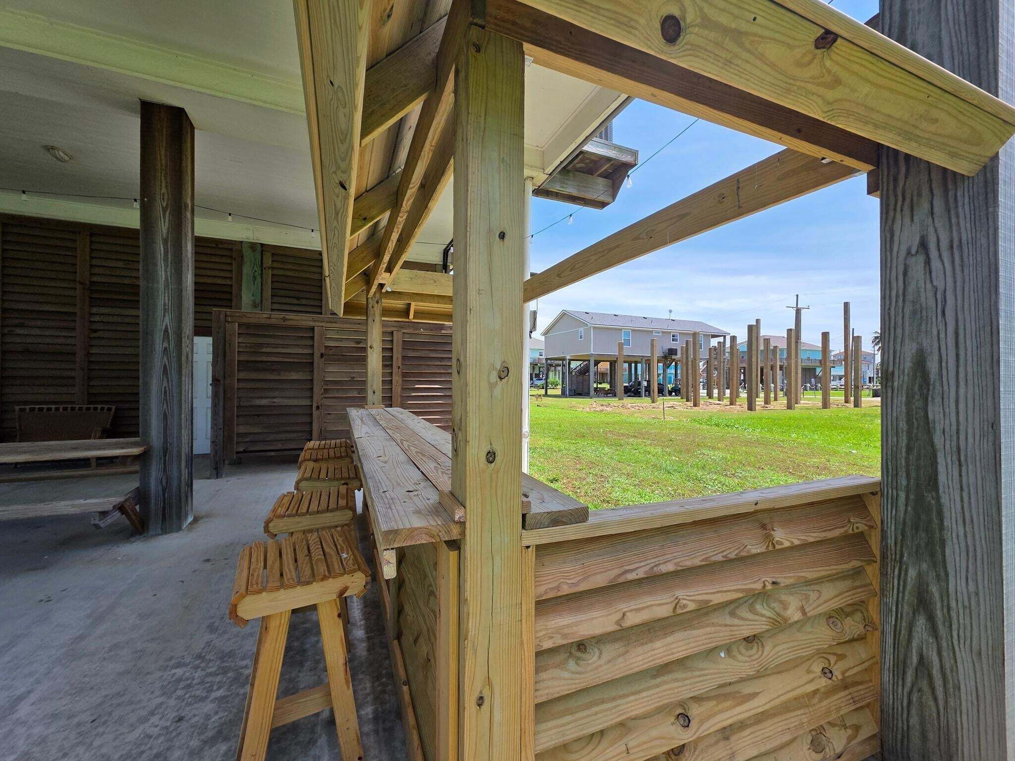 A wooden structure with benches and a view of a residential area.