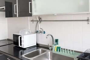 A modern kitchen with a built-in microwave, stainless steel sink, and a towel rack. - Spacious Lisbon Apartment with 4 Bedrooms (Lisboa)