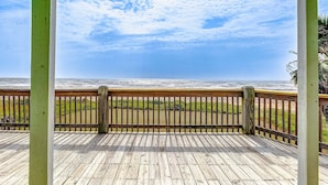 A wooden deck with a railing overlooking the ocean. - Bolivar Bliss 3 Bedroom Home (Port Bolivar)