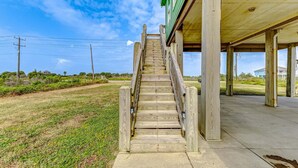 A wooden staircase leading to a covered outdoor area with a concrete floor. - Bolivar Bliss 3 Bedroom Home (Port Bolivar)
