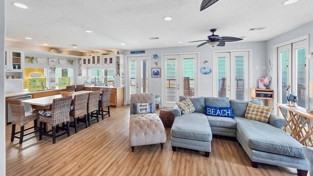 A spacious living area with a dining table, a sofa, and a ceiling fan. - A Stairway To Heaven 4 Bedroom Home (Port Bolivar)