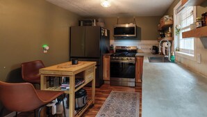 A compact kitchen with a refrigerator, microwave, stove, and wooden cabinets. - Fabulous 3-bedroom cabin in welcoming Webb Lake perfect for relaxing (WEBB LAKE)